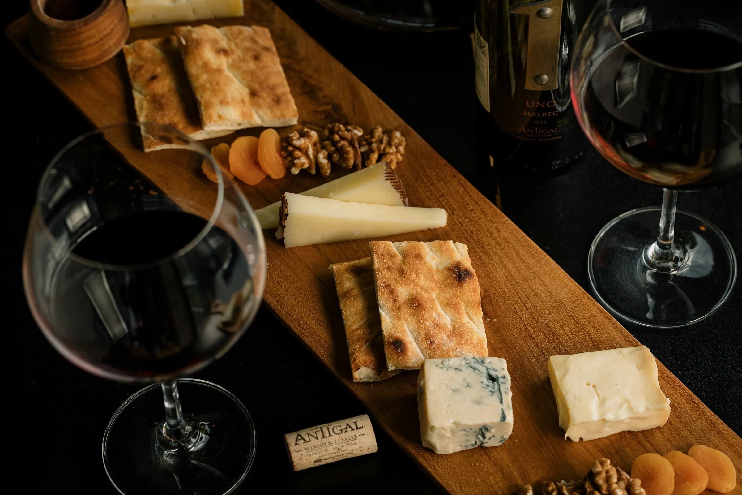 Wijnglazen en kaasplank op een houten tafel