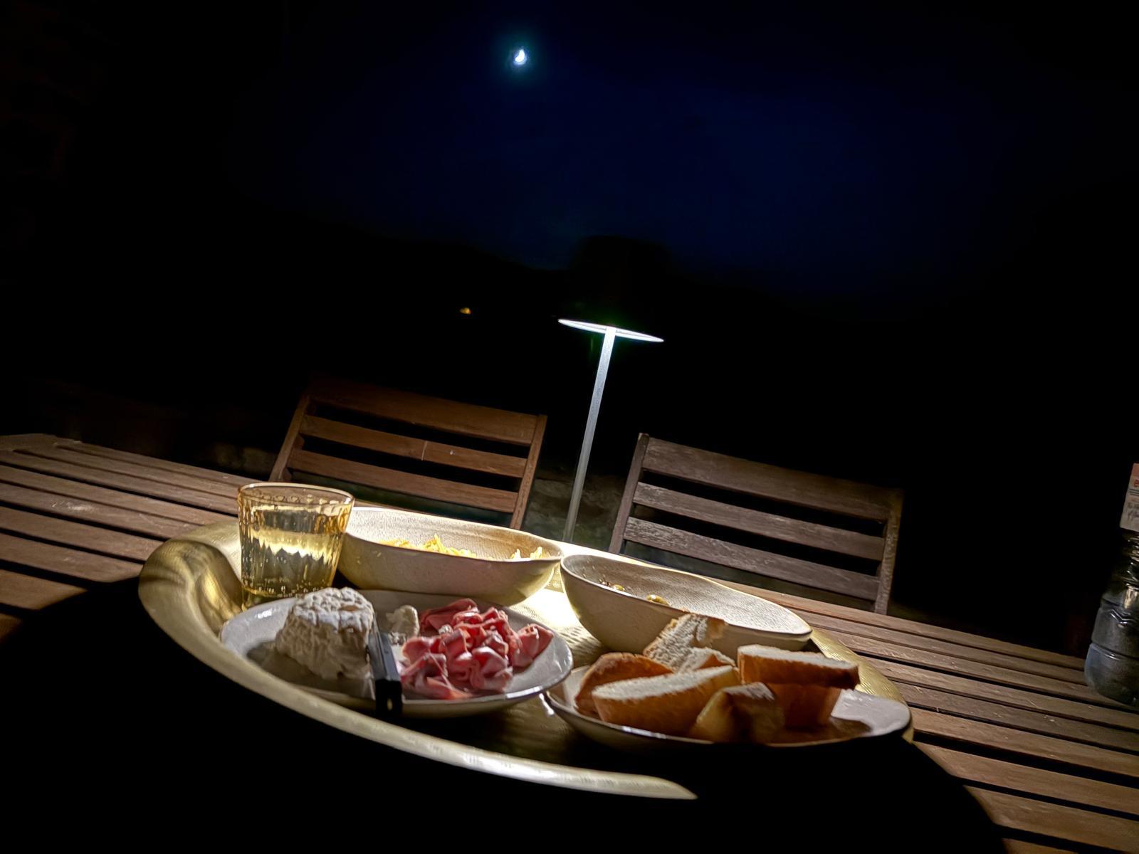 Aperitivo bij maanlicht op het terras — kaas, salumi, brood